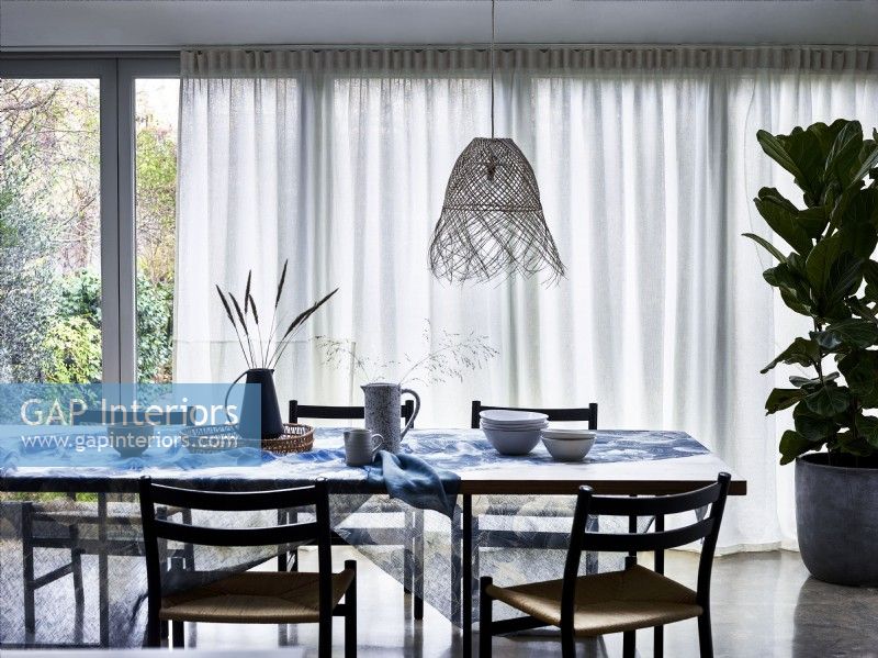 Table à manger avec rideaux diffuseurs en voile blanc