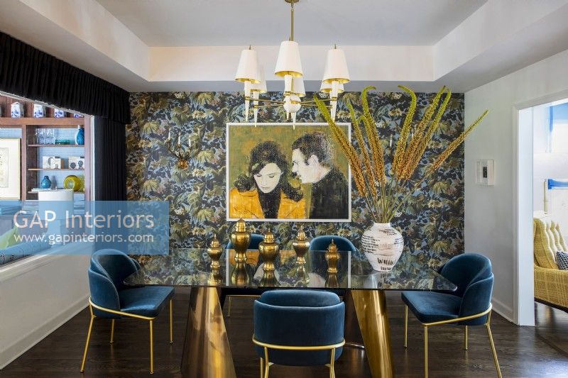 Salle à manger décorée avec papier peint à motifs floraux et peinture de Steve McQueen et Jacqueline Bisset.