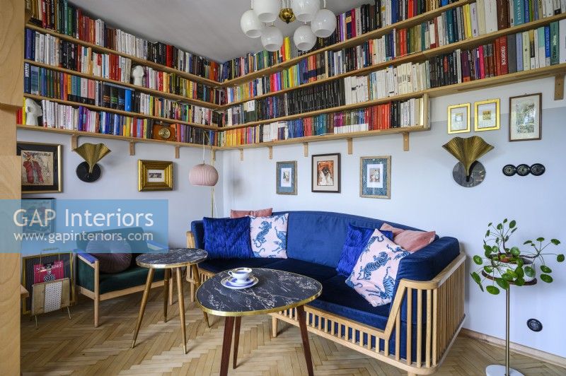 Salon avec un canapé bleu et une collection de livres