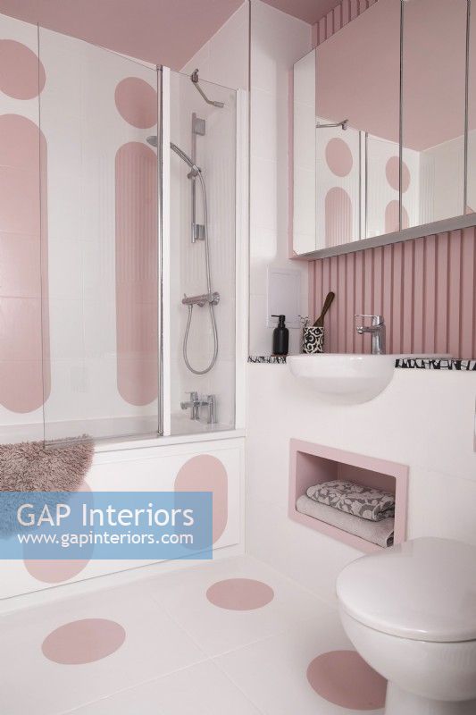 Salle de bain contemporaine avec des formes peintes en rose bauhaus sur les murs et le sol.