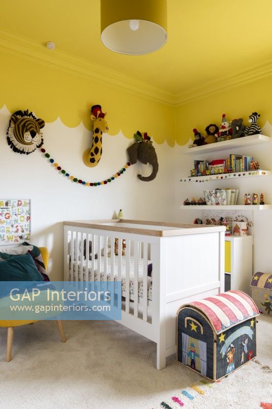 Chambre d'enfant avec lit bébé et plafond festonné jaune