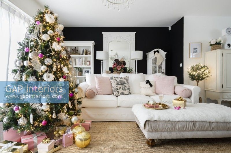 Salon noir et blanc moderne avec arbre de Noël décoré et canapé blanc