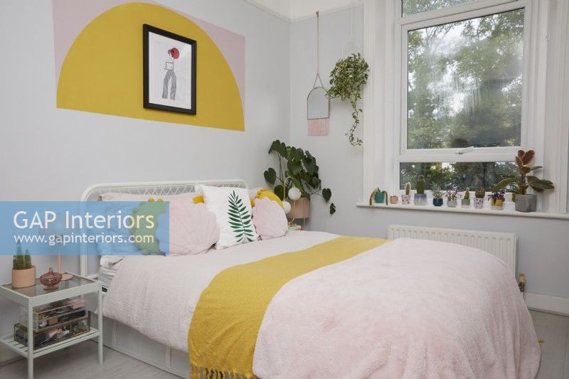 Chambre à coucher avec des formes de blocs de couleur peintes sur le mur.
