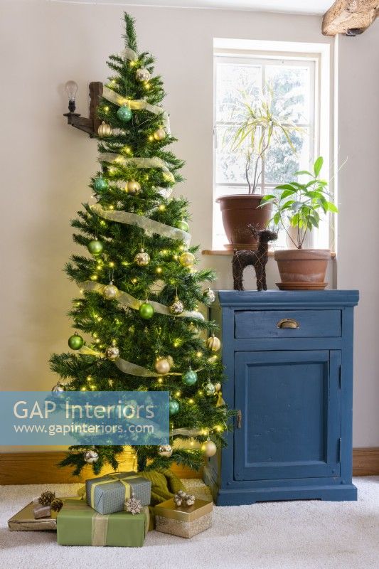 Arbre de Noël à côté d'une armoire peinte en bleu shabby chic recyclé