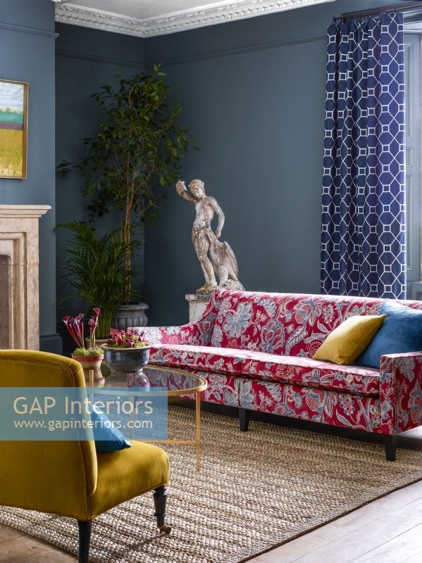 Salon classique avec canapé à motifs rouges et murs bleus