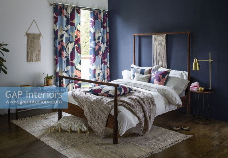 Chambre avec mur peint en bleu et rideaux à motifs