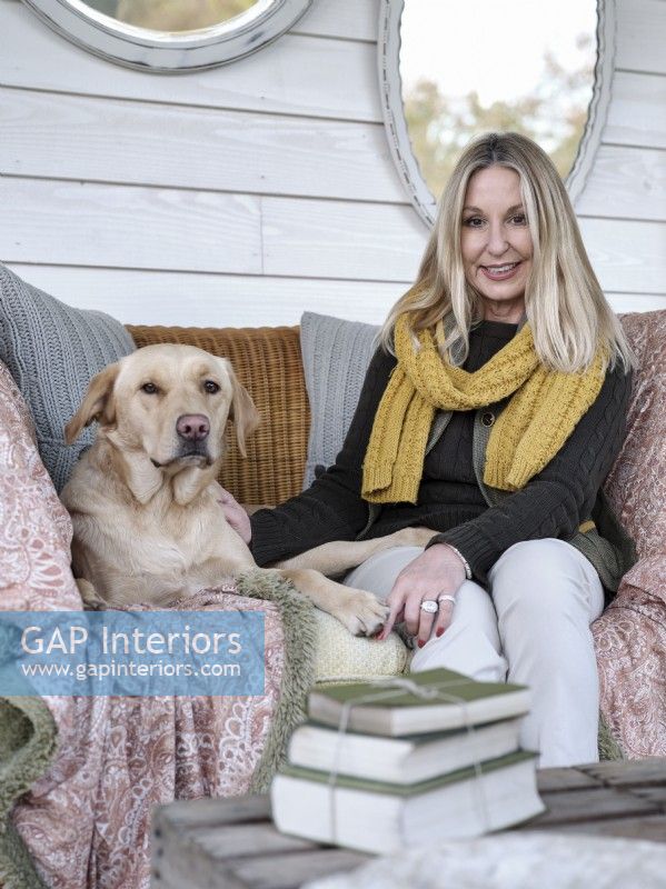Portrait de la propriétaire Tracey Gill sur le porche avec chien de compagnie