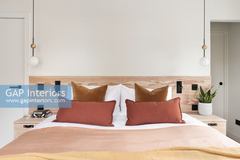 Chambre contemporaine avec tête de lit en bois.