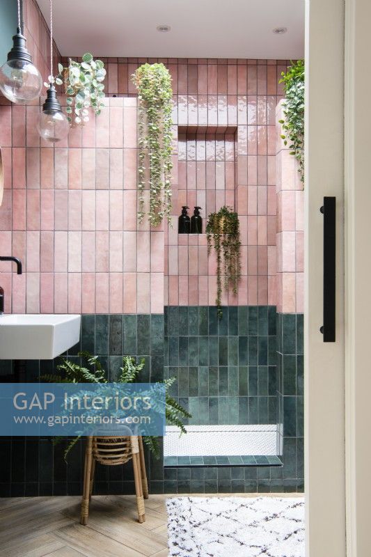 Salle de douche carrelée rose et verte avec porte escamotable coulissante