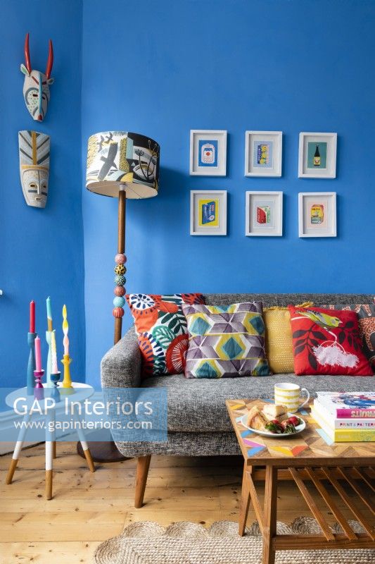 Canapé gris avec coussins dans un salon bleu coloré