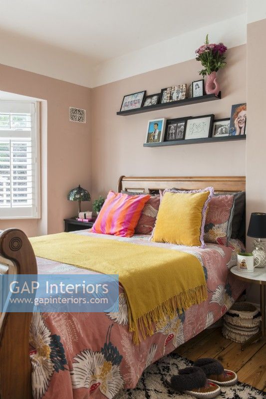 Literie colorée sur un grand lit en bois dans une chambre moderne