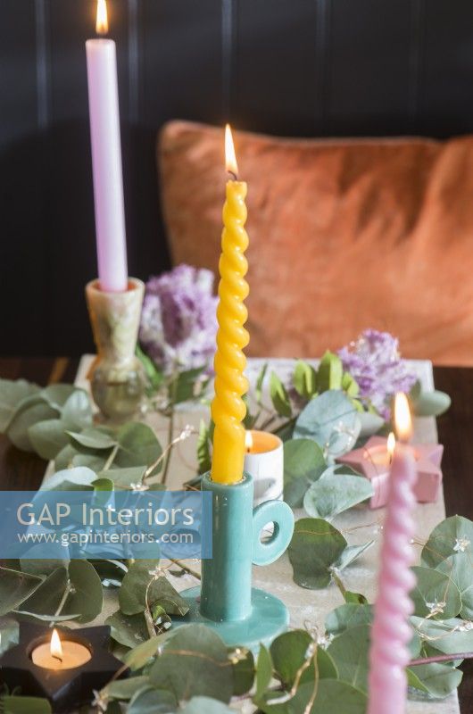 Détail de bougies de couleur pastel sur table à manger