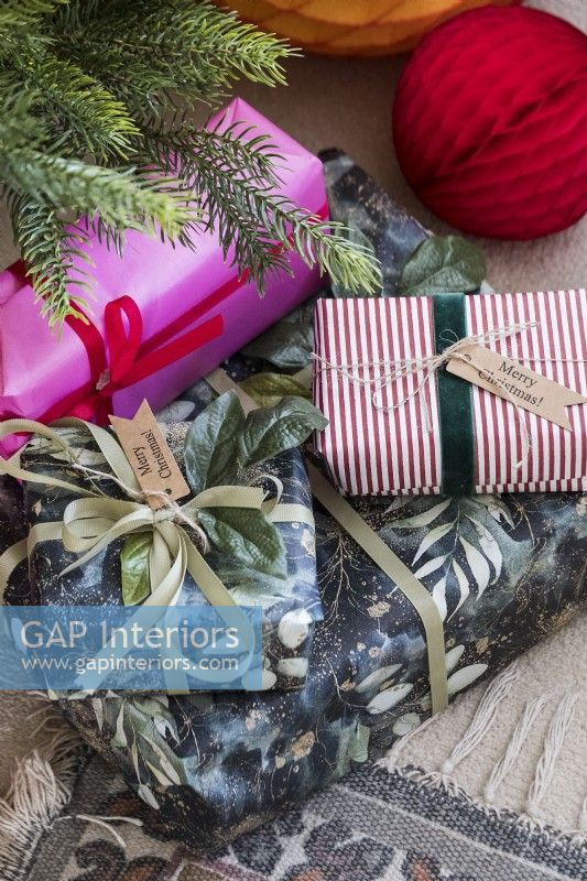 Détail de cadeaux de Noël emballés de couleurs vives sous l'arbre