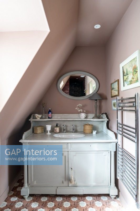 Murs peints en vieux rose et meuble de style vintage avec lavabo