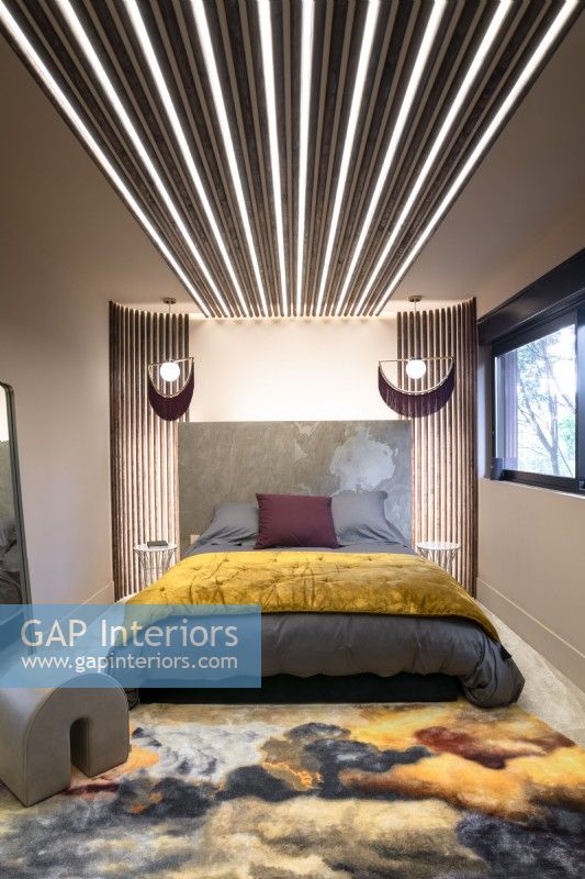 Chambre à coucher contemporaine avec des bandes d'éclairage autour et au-dessus du lit