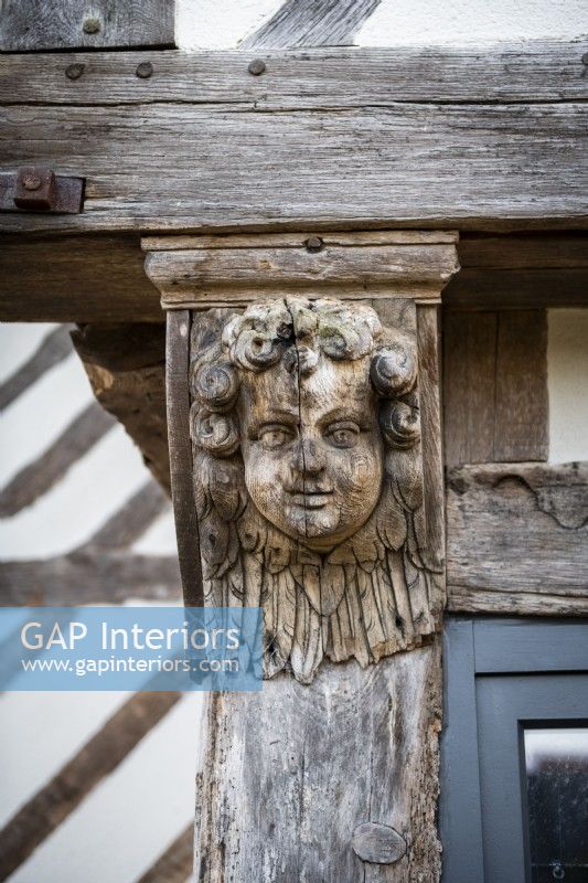 Face en bois sculpté à l'extérieur du manoir du 16ème siècle - détail
