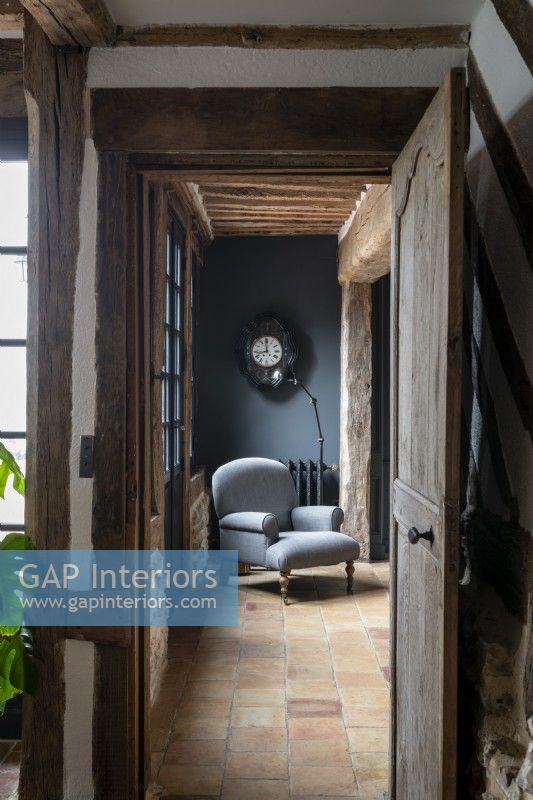 Chaise grise antique dans le couloir de pays avec sol carrelé en pierre