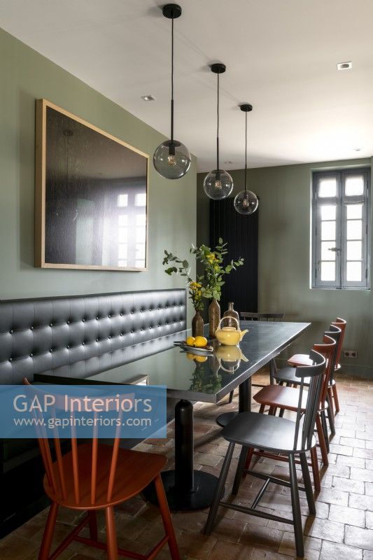 Banquette seat behind black dining table in modern dining room