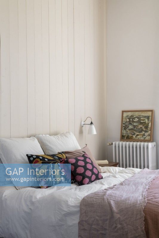 Chambre de campagne simple avec des coussins colorés sur le lit