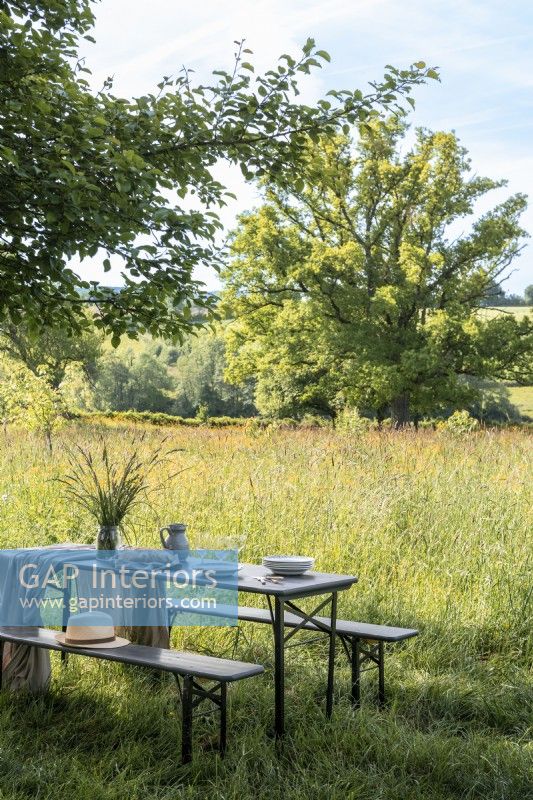 Table à manger en plein air dans un jardin de campagne avec vue panoramique
