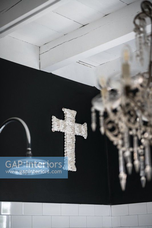 Ornement de croix argentée sur le mur noir de salle de bains