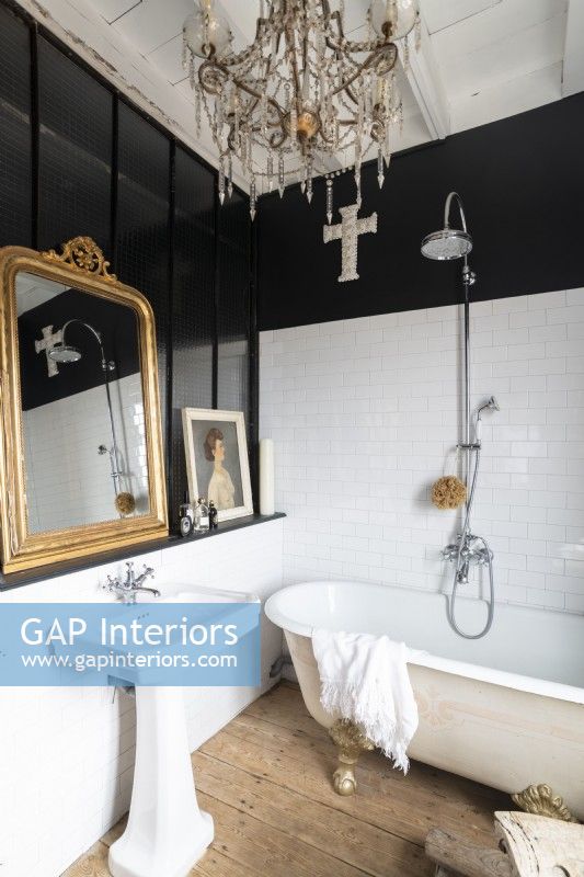 Salle de bains de campagne en noir et blanc avec lustre et miroir doré