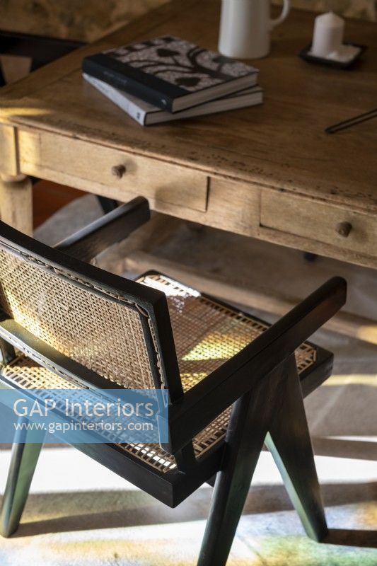 Chaise en bois et rotin noir à côté de la table