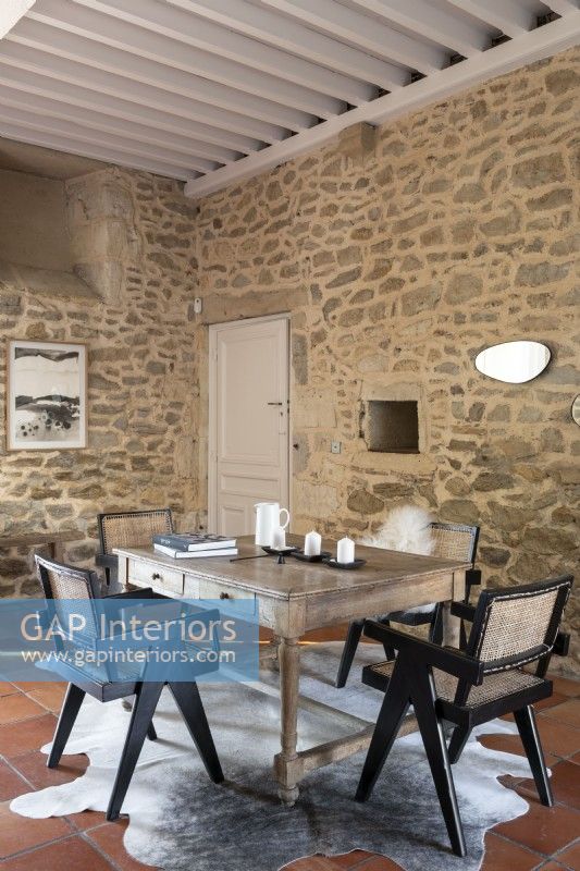Table et chaises en bois dans la salle à manger de pays avec des murs en pierre