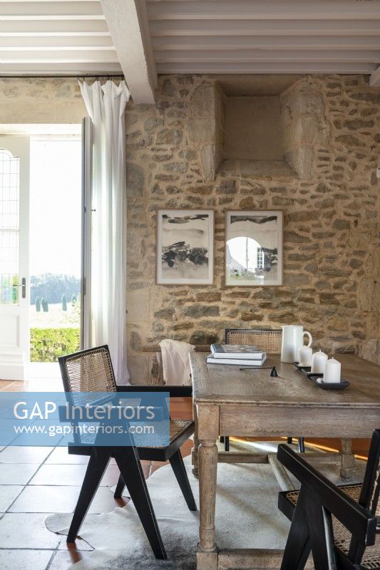 Table en bois et murs en pierres apparentes dans la salle à manger de campagne