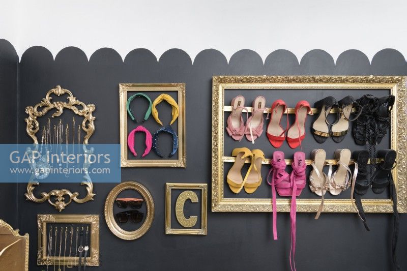 Cadres photo récupérés sur un mur noir pour exposer et stocker des collections de chaussures et de bijoux