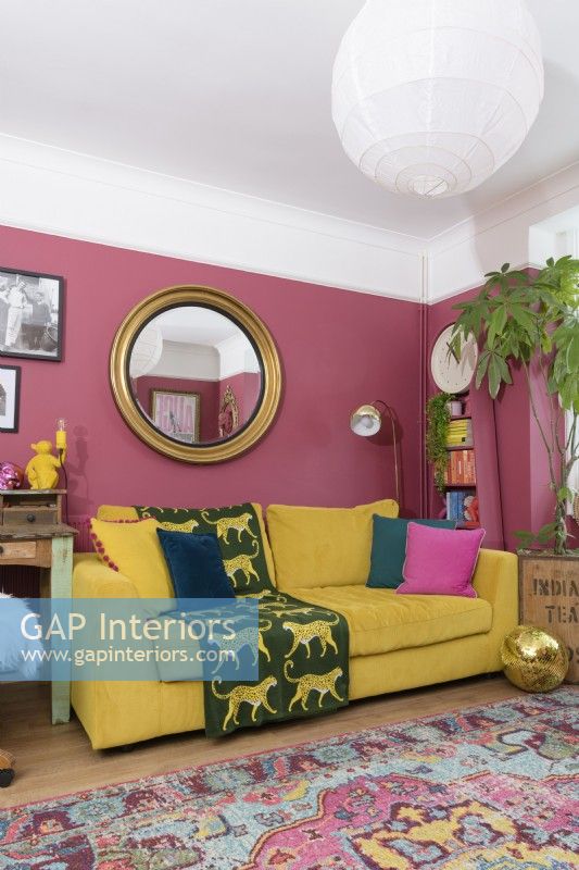 Canapé jaune dans un salon rose