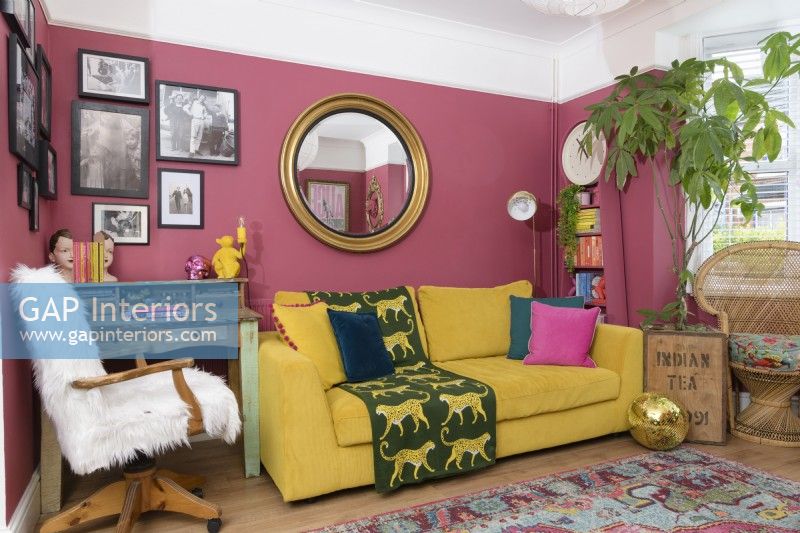 Canapé jaune dans un salon rose