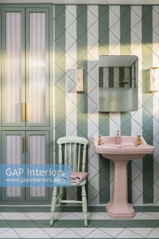 Salle de bain carrelée à rayures vertes et blanches avec vasque rose