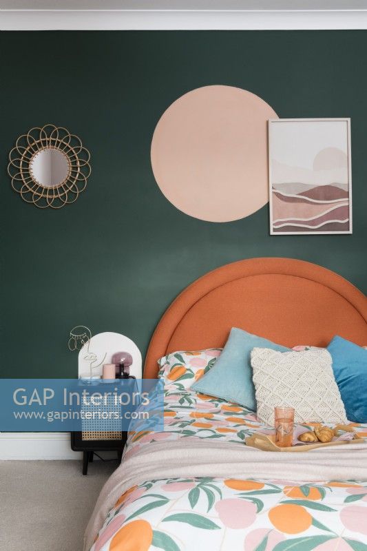 Tête de lit orange contre un mur vert foncé