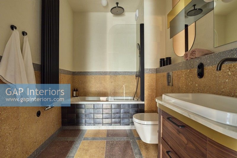 Salle de bain marron avec sol et murs en pierre