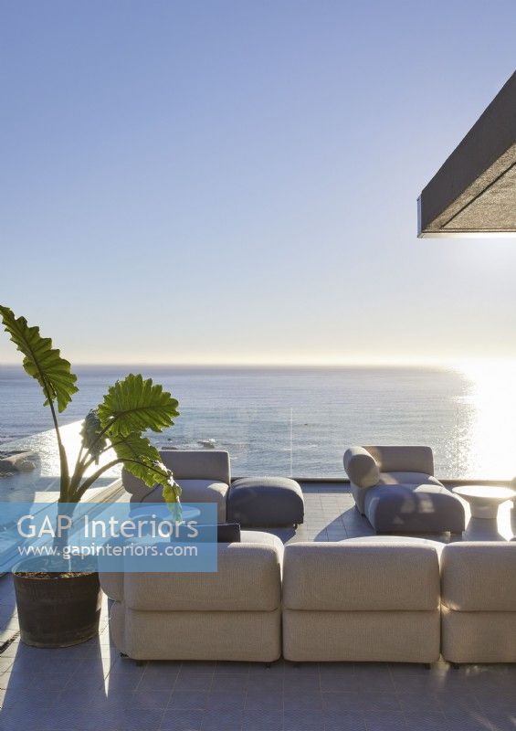 Canapés sur terrasse dans un grand salon extérieur avec vue sur la mer