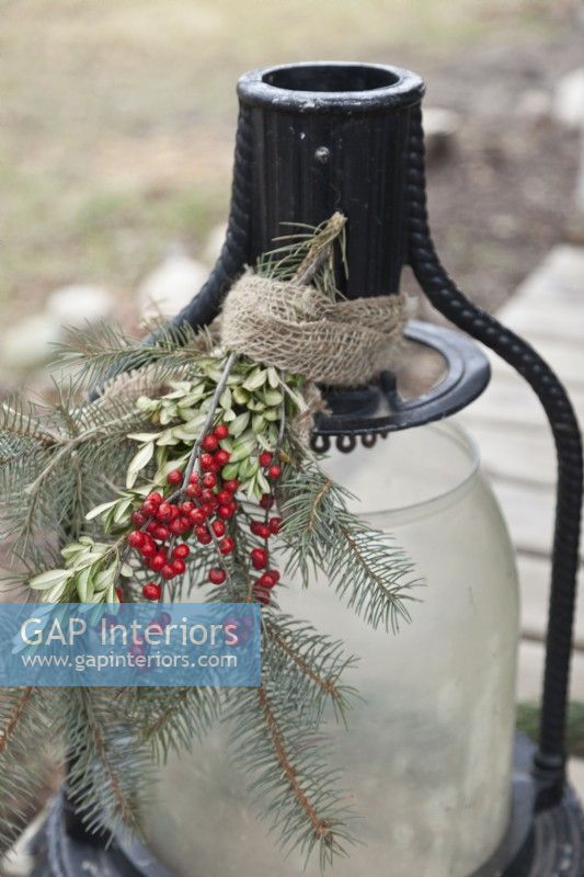 Lanterne extérieure décorée pour Noël avec de la verdure et des baies