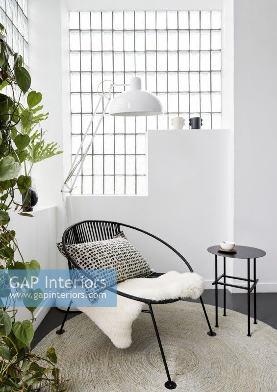 Petite chaise moderne noire et table d'appoint dans un salon moderne blanc