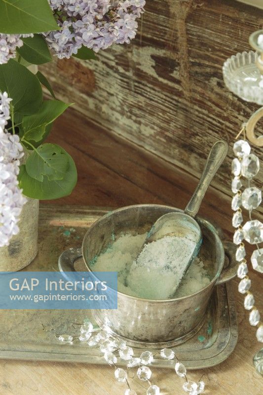 Détail des sels de bain dans un bol en argent sur un plateau en argent et détail des cristaux du candélabre.