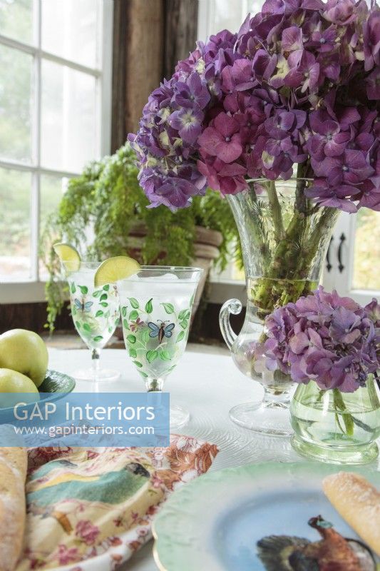 « J'adore les hortensias. C'est tellement la Nouvelle-Angleterre ! », déclare Ellen. Des bouquets de fleurs violettes ornent des vases anciens de brocante.