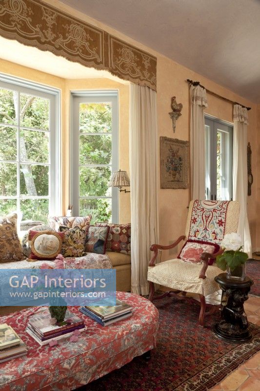 Un siège de fenêtre invitant et une chaise française recouverte de housse sont situés au cœur de la grande salle. Un défilé d'oreillers chics présente une mini-histoire de l'art textile.