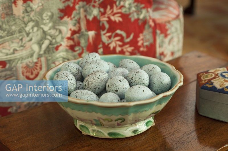 Un bol en majolique antique dorlote des œufs bleus célestes.