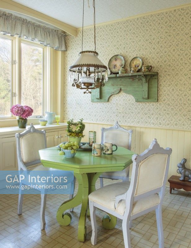 Inondé de charme champêtre, le coin petit-déjeuner est centré sur une table vert vif entourée de chaises de friperie.