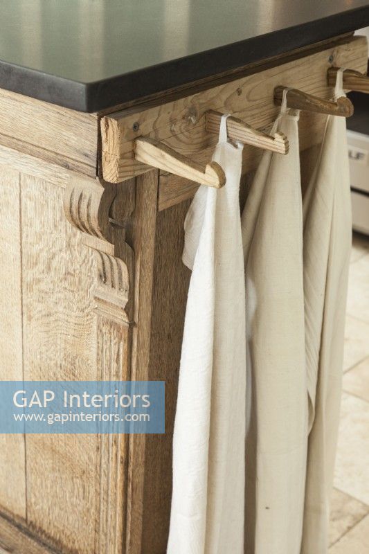 Des chevilles en bois fixées à une planche de finition similaire constituent un porte-serviettes élégant et efficace.