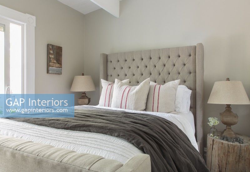 Les hauts plafonds de l'appartement peuvent accueillir le lit abri capitonné avec pied de lit. La palette neutre des lins est animée par la variété des textures.