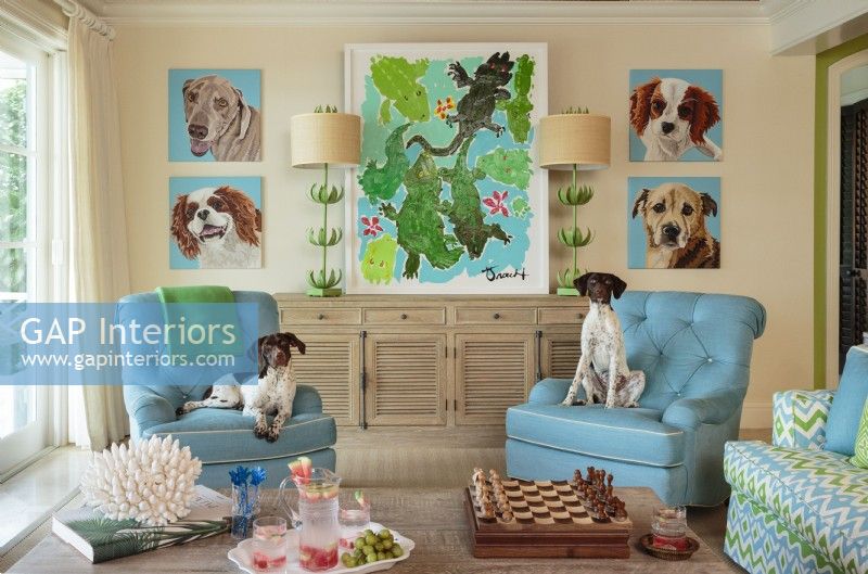 La famille appelle cet espace 'la salle des chiens' car il présente des portraits d'anciens animaux de compagnie, mais c'est aussi l'endroit où ils se réunissent avec leurs enfants et leurs chiens actuels.