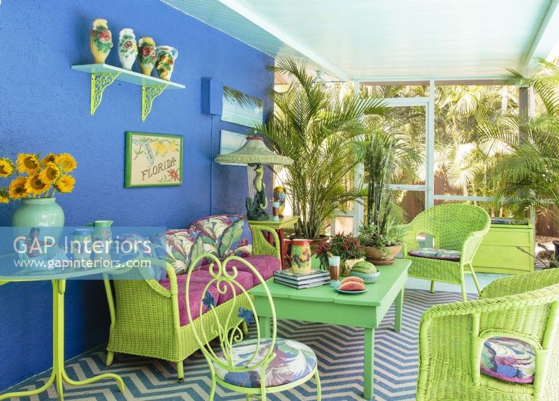 Un mobilier coloré crée une ambiance tropicale dans un autre porche couvert.