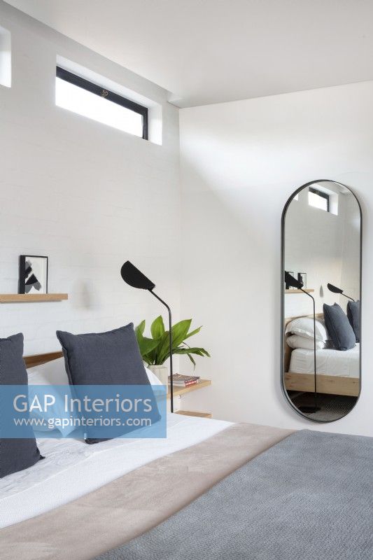 Oval mirror in modern bedroom