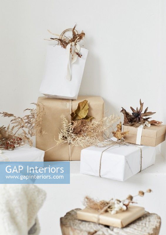 Cadeaux de Noël emballés en marron et blanc avec des décorations naturelles