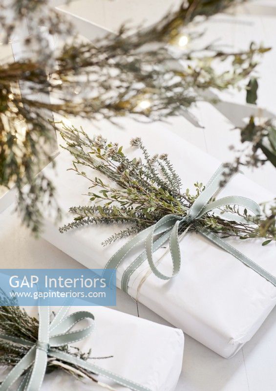 Détail de cadeaux de Noël blancs avec des décorations naturelles